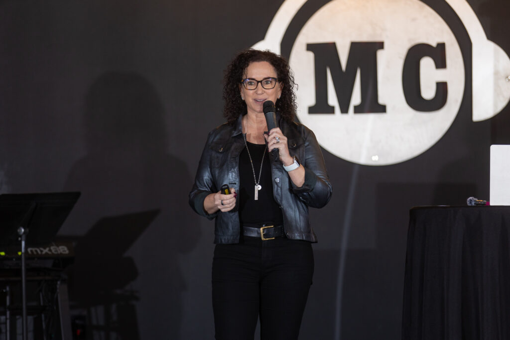 Simone Knego speaking on stage