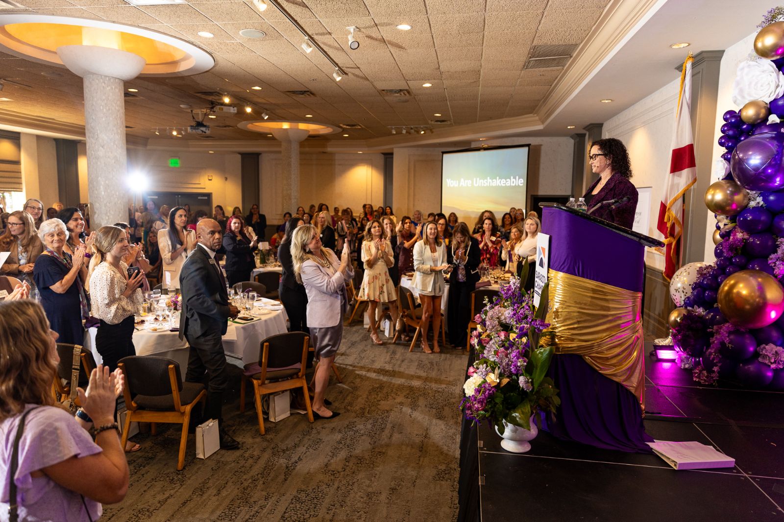 Simone Knego, women's leadership keynote speaker, receiving a standing ovation